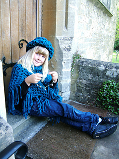 Beth_poncho_sitting_down_by_door_with_daisy_chain_small2