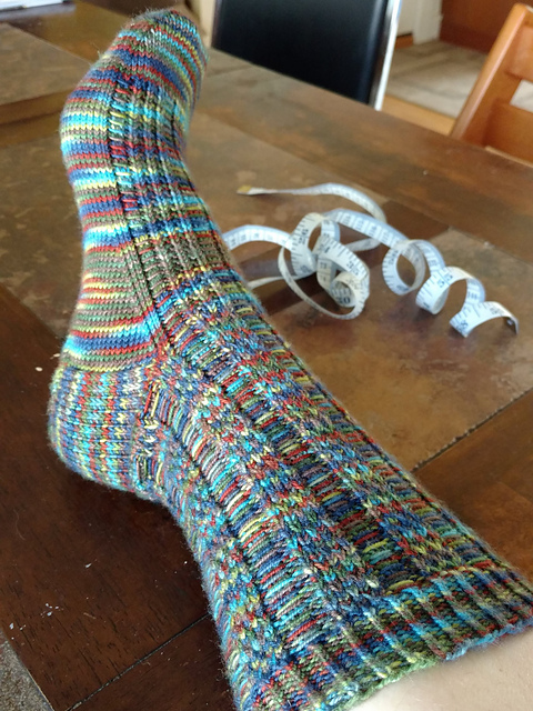 hand knit sock on table with tape measure in background